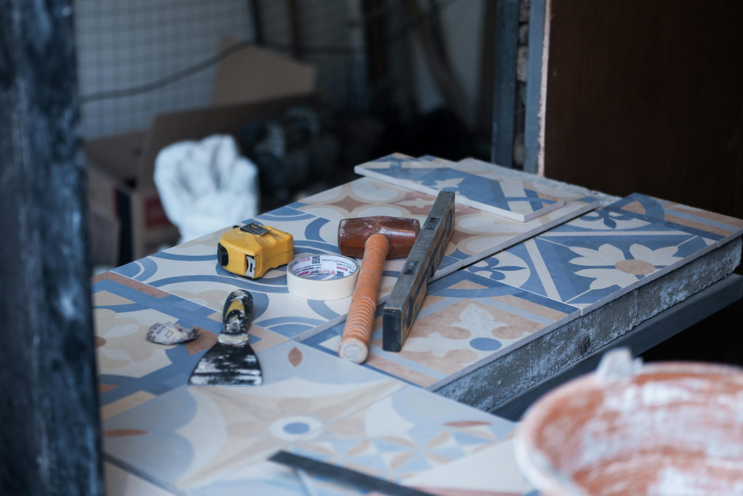 putty knife, tape, and other tools on a tiled countertop